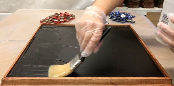 The epoxy seal coat application method being demonstrated with a brush.