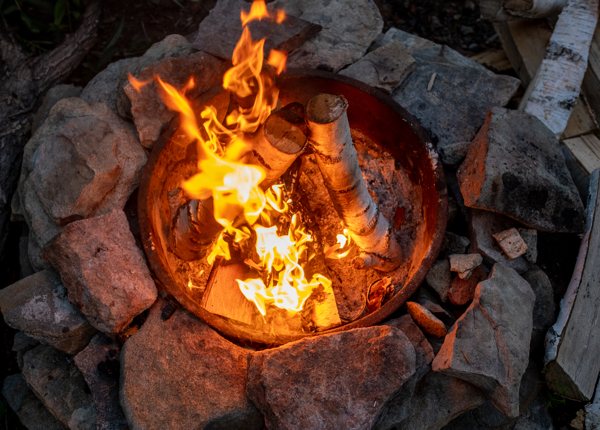 A stone firepit with a blazing flame.