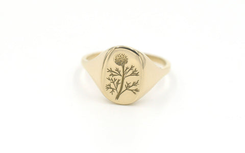 Yellow gold signet ring by Erin Claus with dandelion engraving