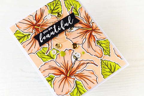 A "you're beautiful" card  with orange flowers in the background and gold-and-silver sequins as embellishments