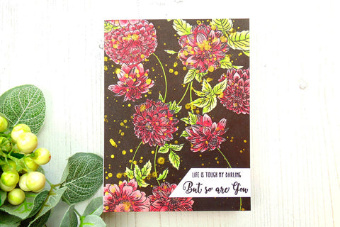 A floral card on a dark background with ink splatters as embellishments