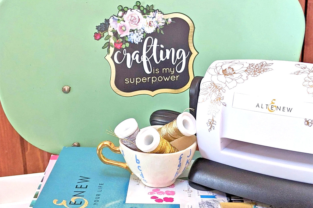 Altenew crafting supplies and tools on a green armchair with a "Crafting is my superpower" decal