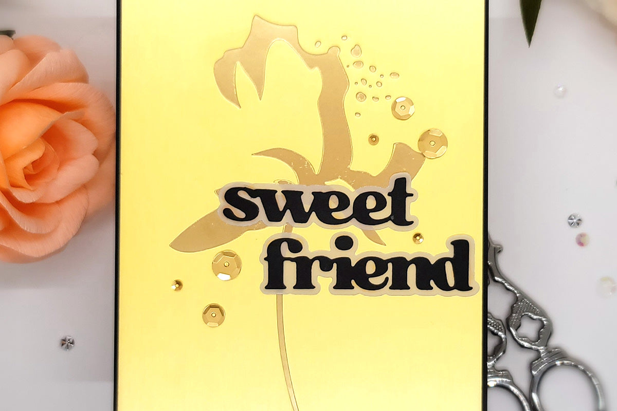 Friendship card with a gold foiled outline of a flower and a yellow background
