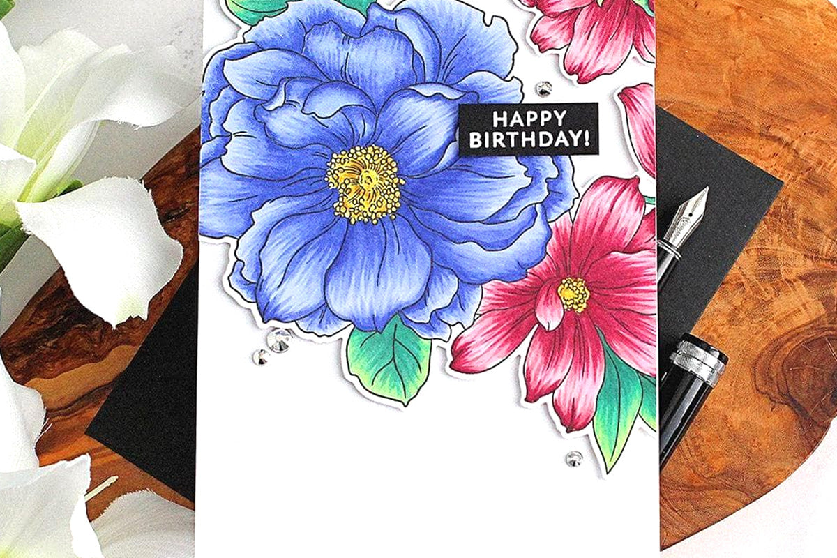 A birthday card with red and blue flowers as focal points created with Altenew's Artist Alcohol Markers
