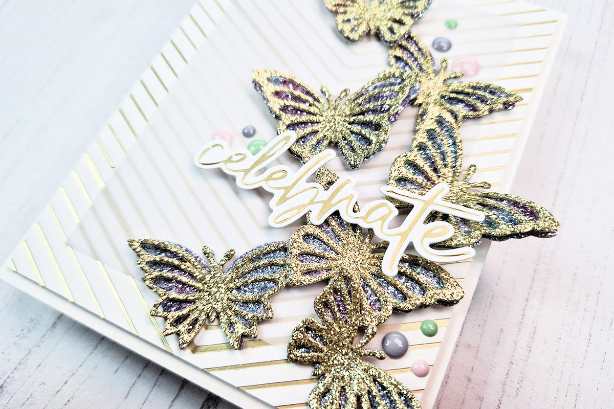 A "celebrate" card with gold glitter butterfly die-cuts, colored with alcohol inks