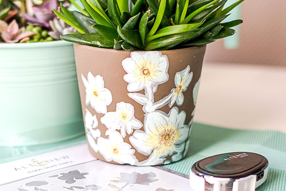 A flower pot decorated with stenciled flower designs
