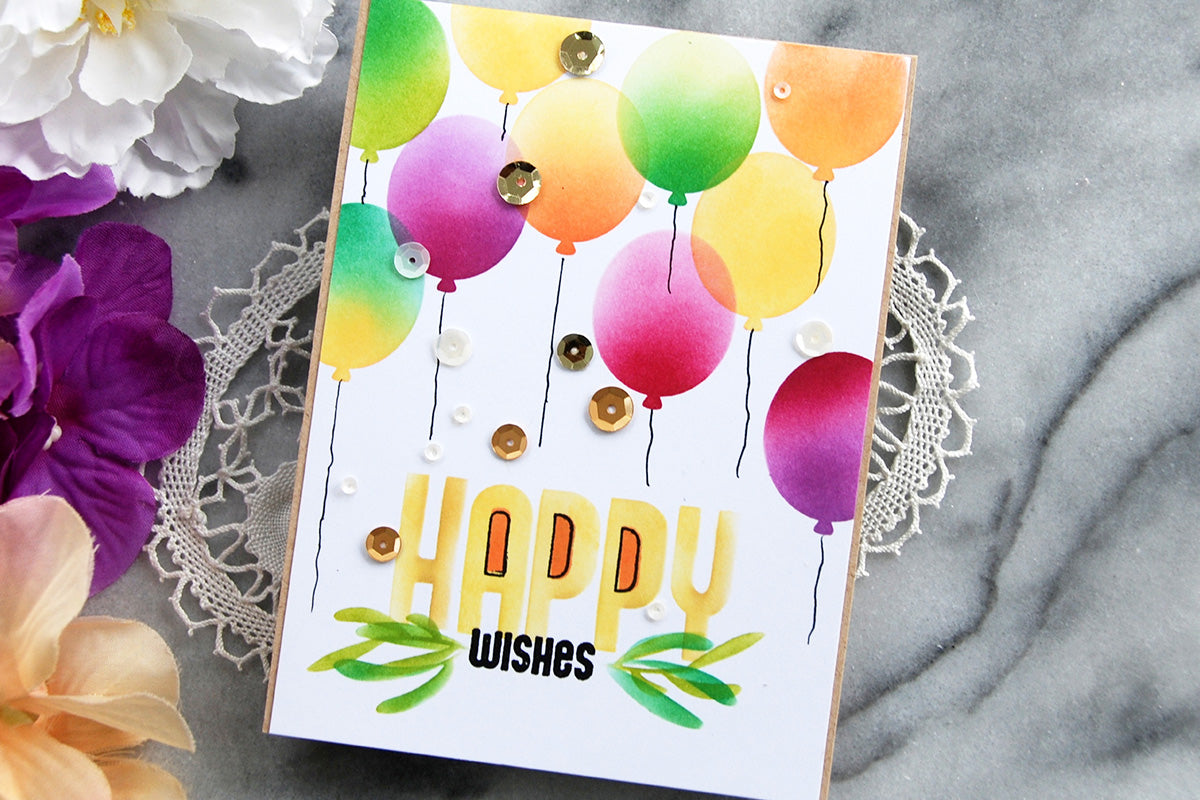 Colorful birthday card with different colored stenciled balloons and sequins