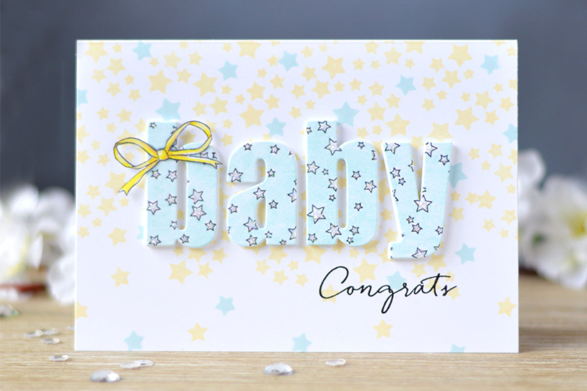 A congratulations card for a couple with a new baby, decorated with blue and yellow stars