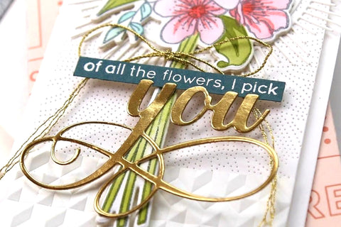 A mixed media card with a floral bouquet as a centerpiece and gold embossed sentiments saying "Of all the flowers, I pick you"