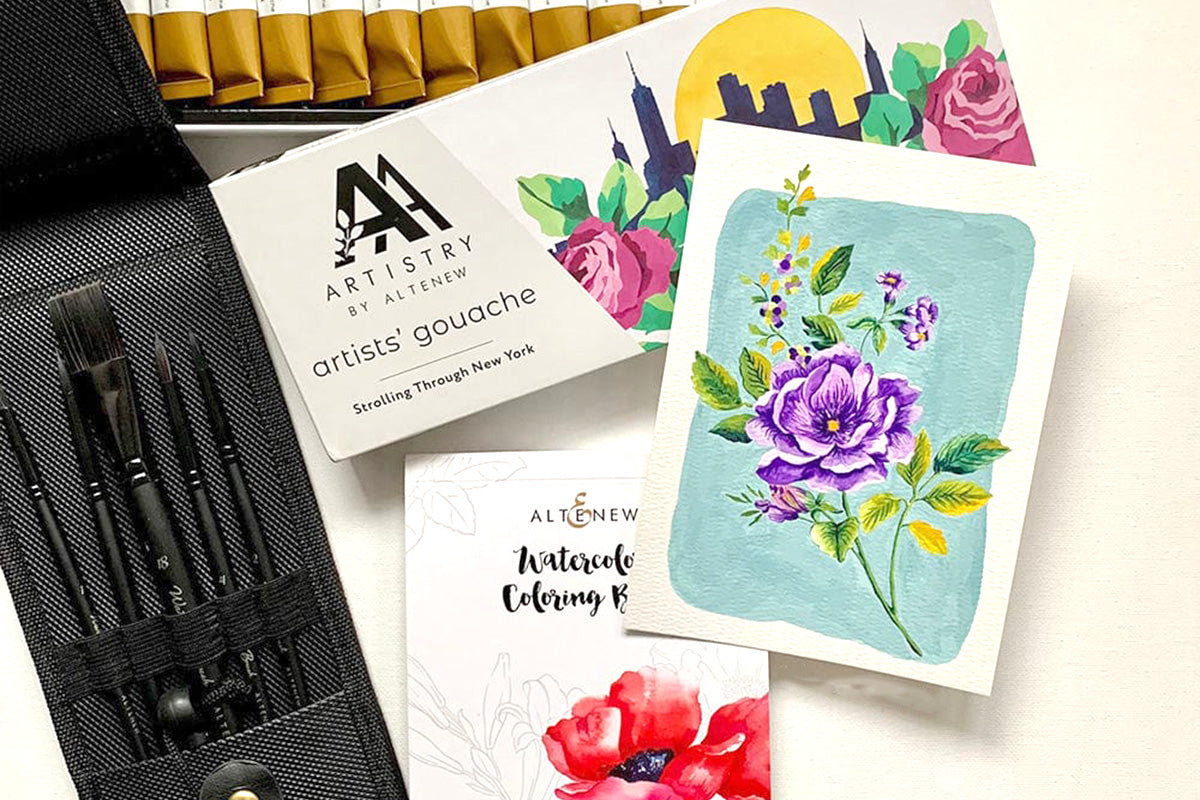 A floral card with various artists tools like Artistry by Altenew's Artists' Gouache: Strolling Through New York, Altenew's Watercolor Coloring Book, and paintbrushes