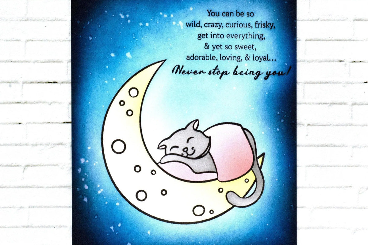 A lovely card of a night sky and a sleeping cat on a glowing moon, colored in with pigment ink
