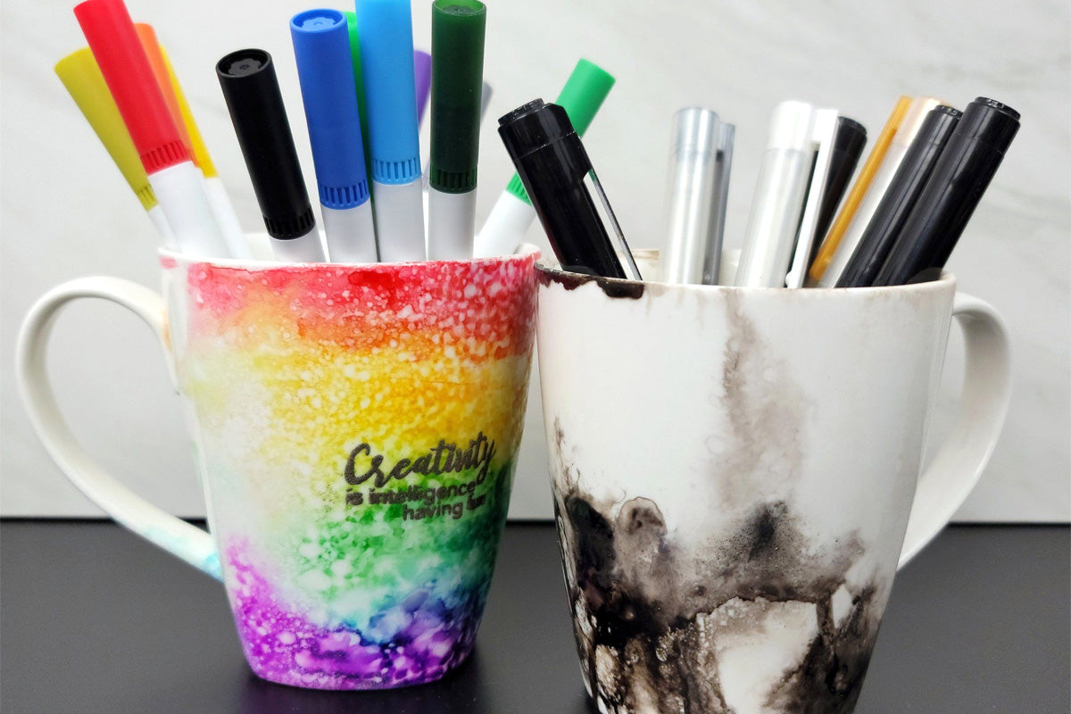 DIY mugs decorated using alcohol inks, stamps, and pigment ink, and repurposed as marker and pen holders