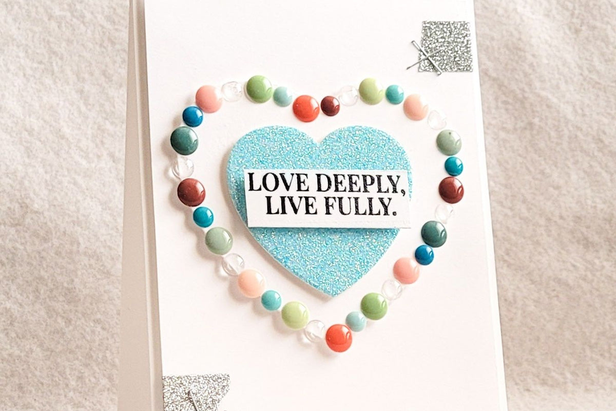 CAS greeting card featuring a heart-shaped die-cut decorated with colorful enamel dots.