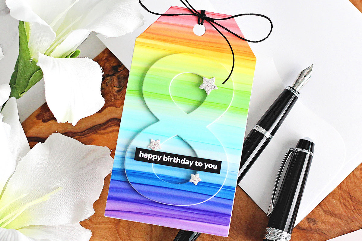 A beautifully colored rainbow tag colored with alcohol markers