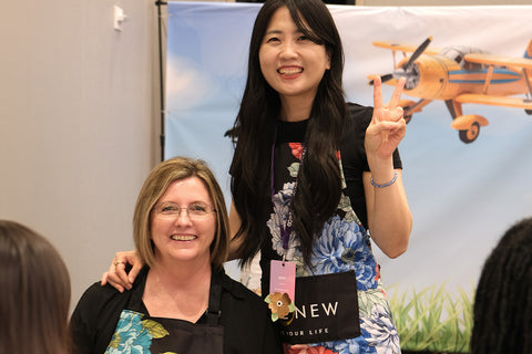 May Park and April Leithner smiling big and wearing Altenew Artsy Aprons at the Go Wild Planner Conference 2024