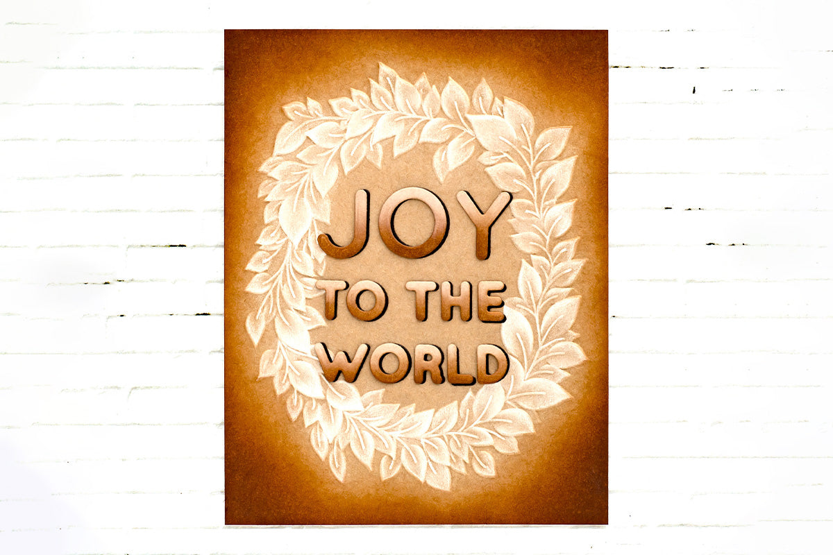 Handmade Christmas card with a glowing leafy wreath and the sentiment "Joy to the World"
