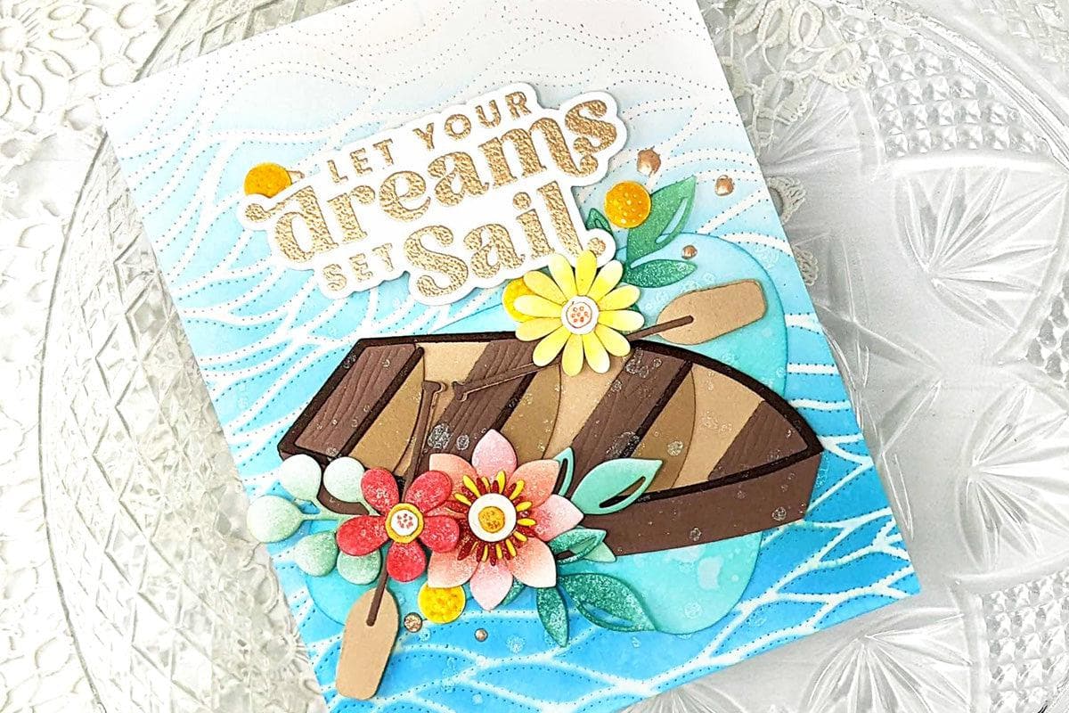 A lively card featuring a rowboat die-cut with flowers against a debossed background