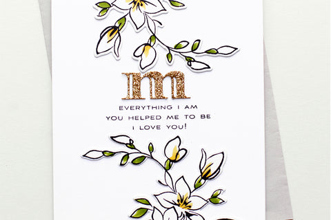 Clean and simple handmade Mother's Day card with white flowers and the letter "m" die-cut from gold glitter cardstock