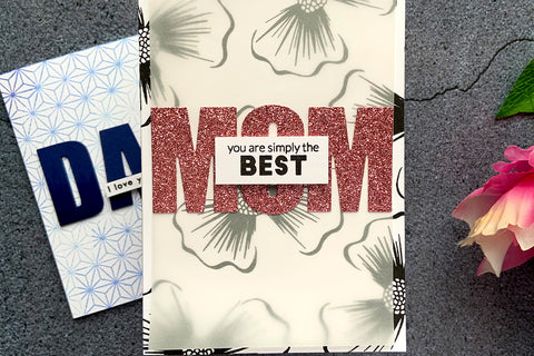Floral handmade Mother's Day card with the word "mom" die-cut out of glittered cardstock