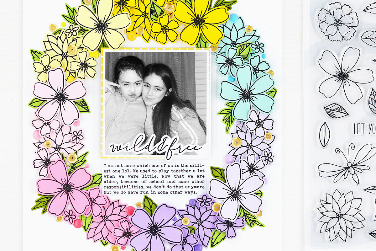Colorful and layered scrapbook layout with a flower wreath and a photo of two sisters in the middle