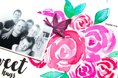 A close-up shot of a DIY scrapbooking page with a black and white photo of a dad and his sons and watercolor flowers