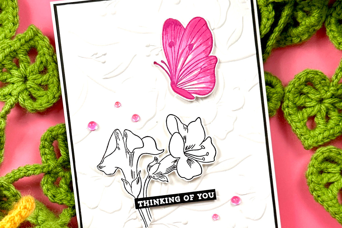 DIY card with 3D embossed white background, flowers, and a pink butterfly