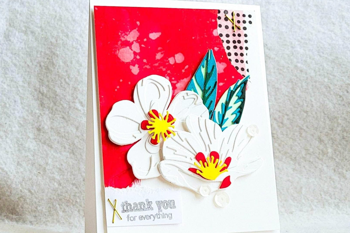 A thank you for everything card with a colored cardstock background and some white floral die-cuts as focal points