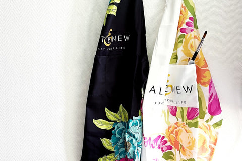 2 variations of the new crafting aprons from Altenew - one in black and one in white, hanging on a wall