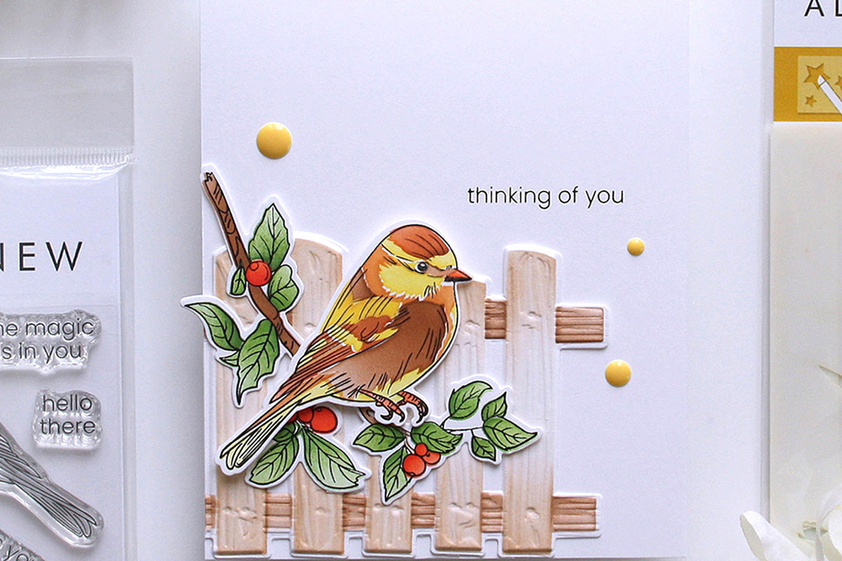 A nature themed handmade card with the sentiment "thinking of you" and a bird perched on a wooden fence