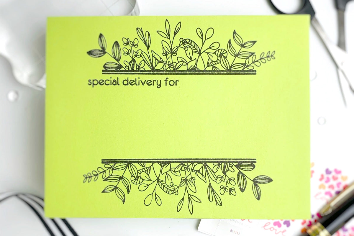 Green card envelope decorated with stamped floral images from Altenew Envelope Art stamp set