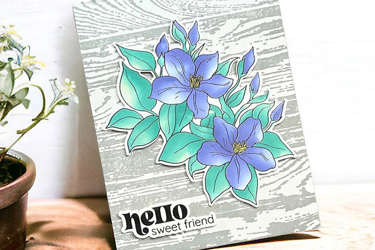 Greeting card with purple jasmine flowers popped up against a wood press plate background