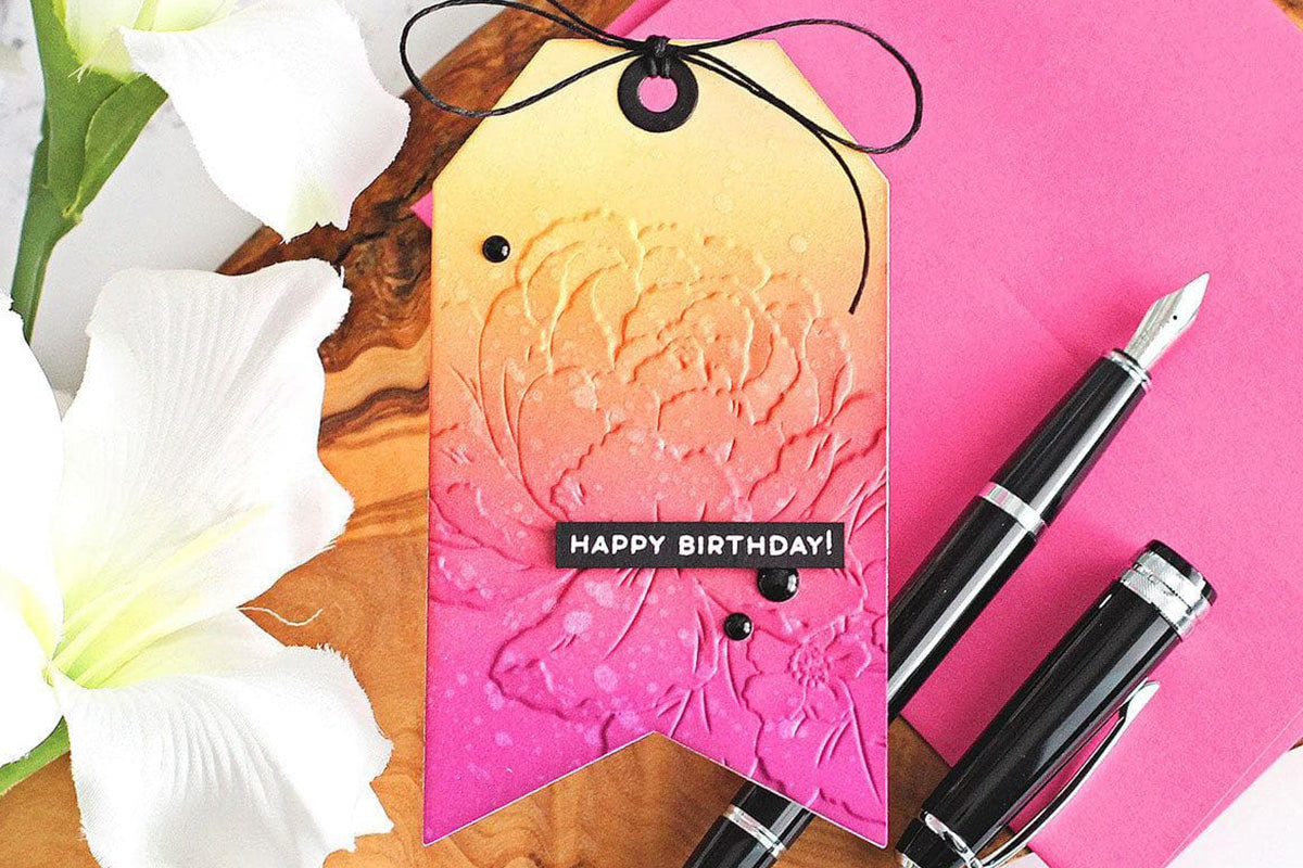 A pink-and-yellow birthday tag embossed with the 3D embossing folder from the Craft Your Life Project Kit: Delicate Garden