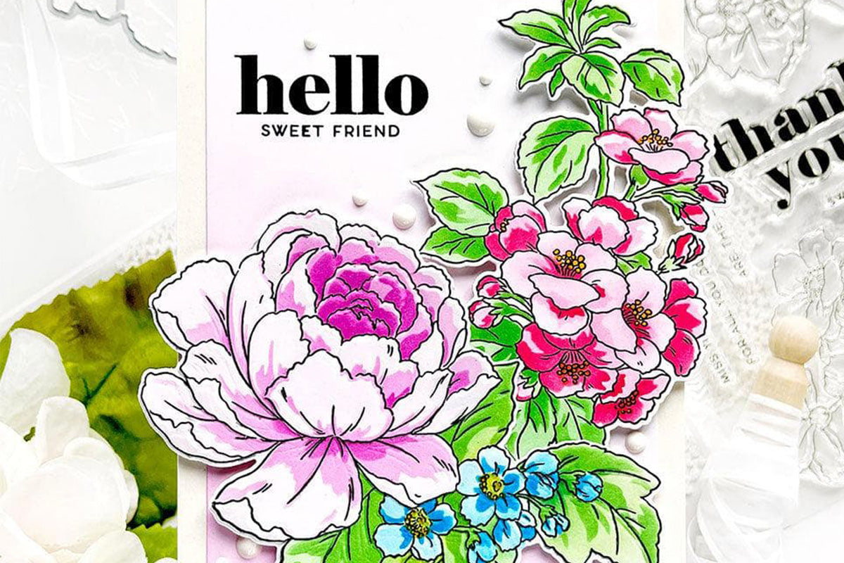 A greeting card with a big pink flower, and small blossoms of red and blue, created with the Craft Your Life Project Kit: Delicate Garden