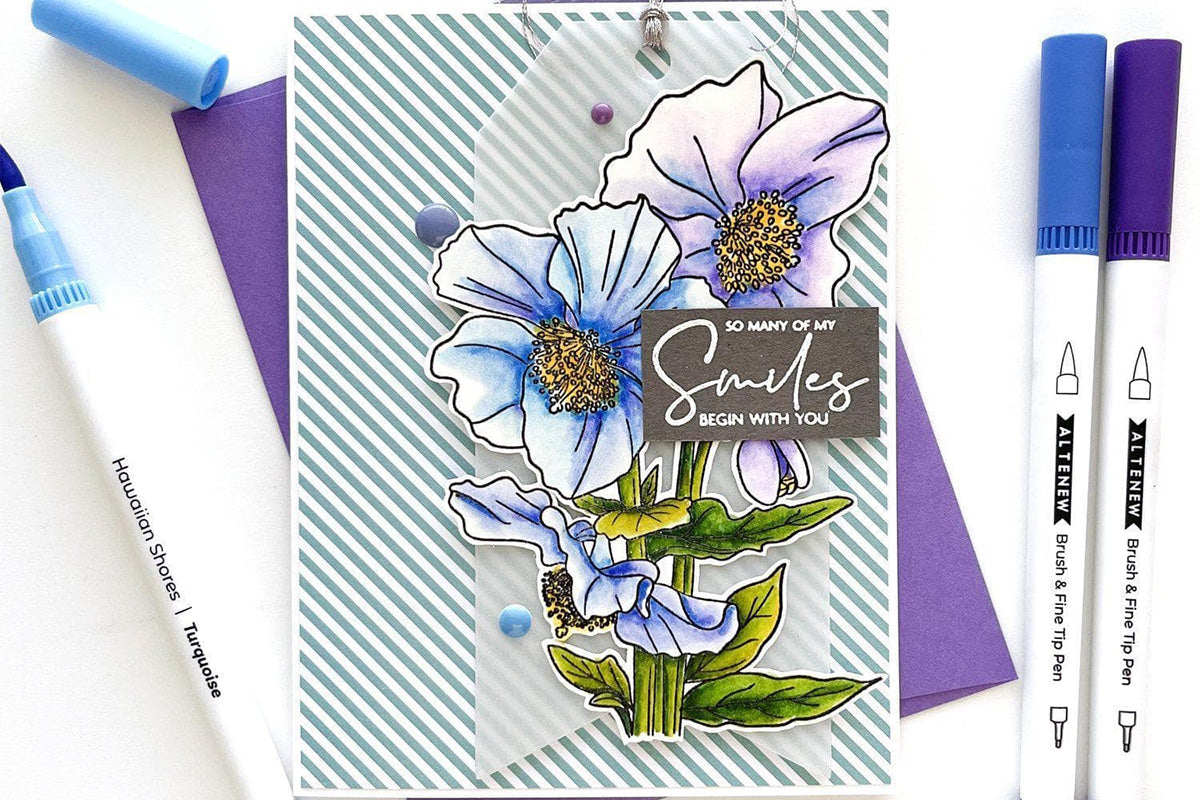 A greeting card with a striped background and two flowers, blue and purple, as the focal point, colored in with Altenew's Hawaiian Shores Dual Tip Pens (Water-based)