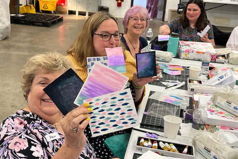 A group of crafters happily showing off their handmade cards at Altenew's Meet and Greet in New York
