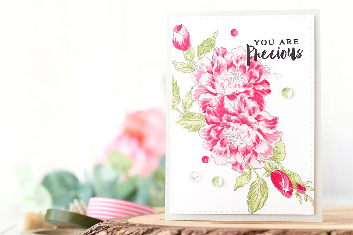 Handmade floral card with pink blooms and some leaves and foliage and the sentiment "you are precious"