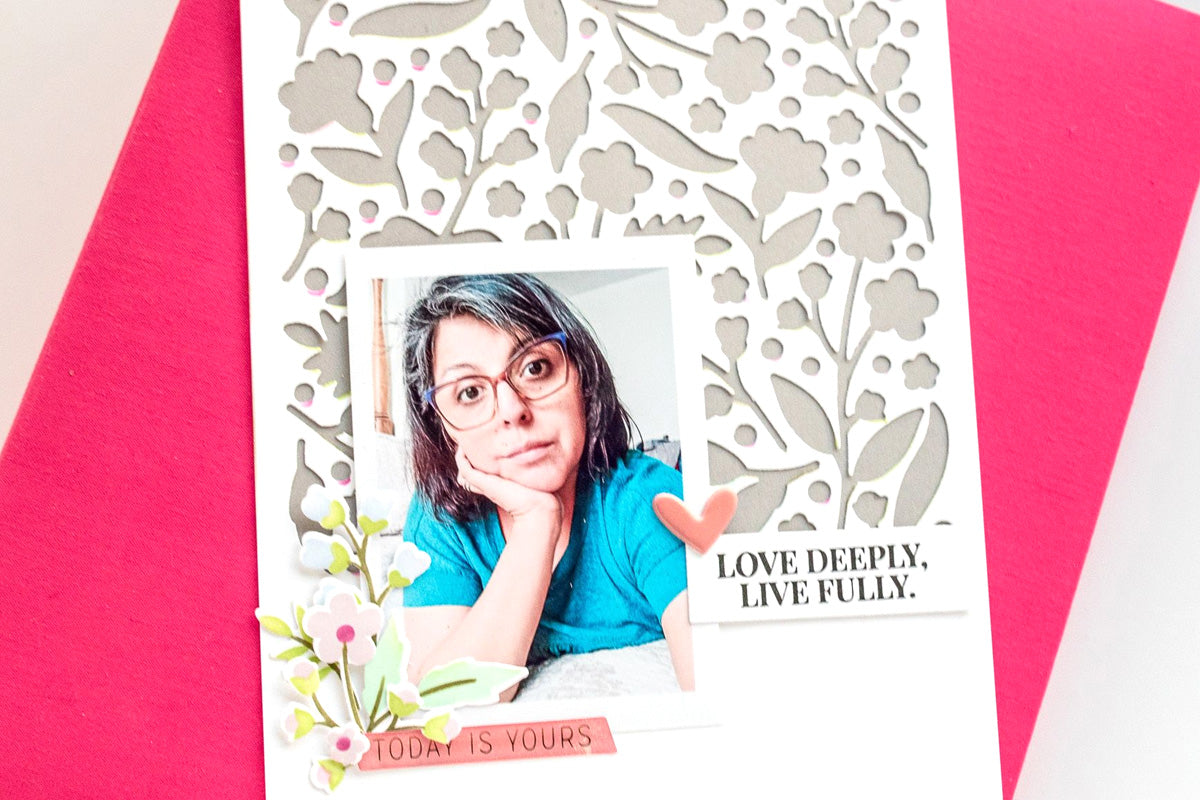 A DIY scrapbook page with a floral negative die-cut as the background