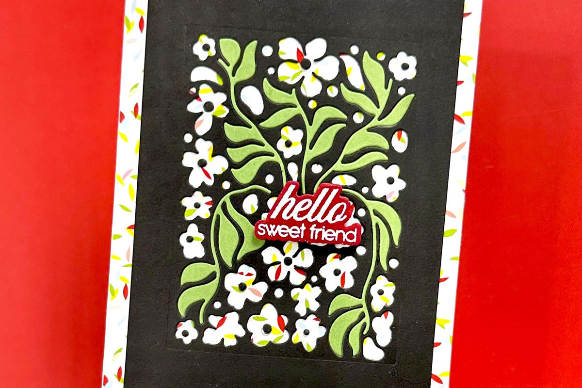 A masculine handmade card featuring floral and foliage die-cut pieces and a black background