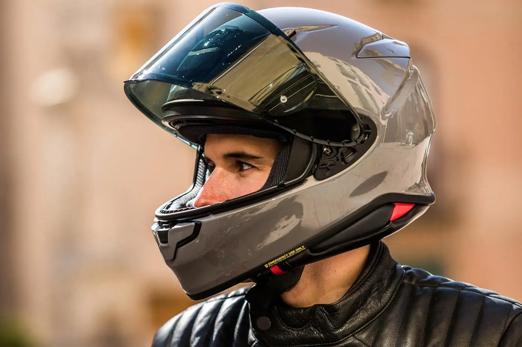 Un motociclista con casco gris