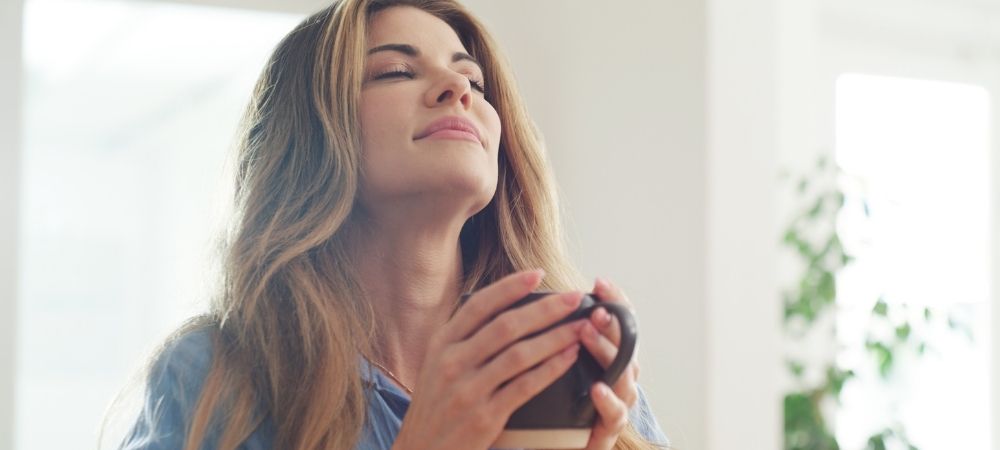 Frau genießt Kaffee ohne Koffein von OHNE und findet Kaffee gesund