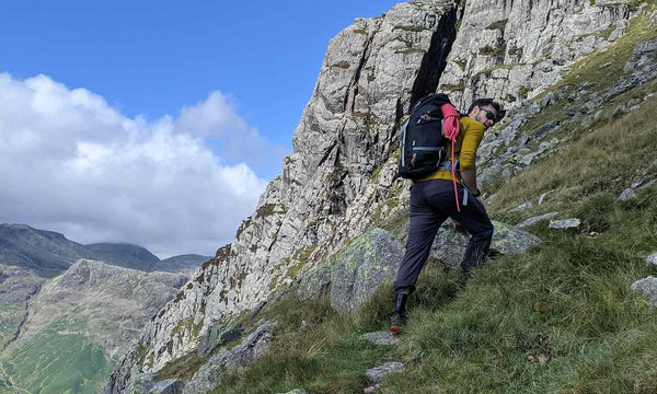 outdoor rock climber climbing a hill in the lake district with rope bag