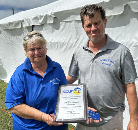 Micki and G.C. hold up their award for playing a major role in the success of the Winter Star Party in the Florida Keys.