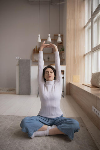 Girl performing sitting side stretch as part of a 10 minute stretch routine.