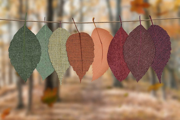 Paper leaves in autumn colors hang on rope