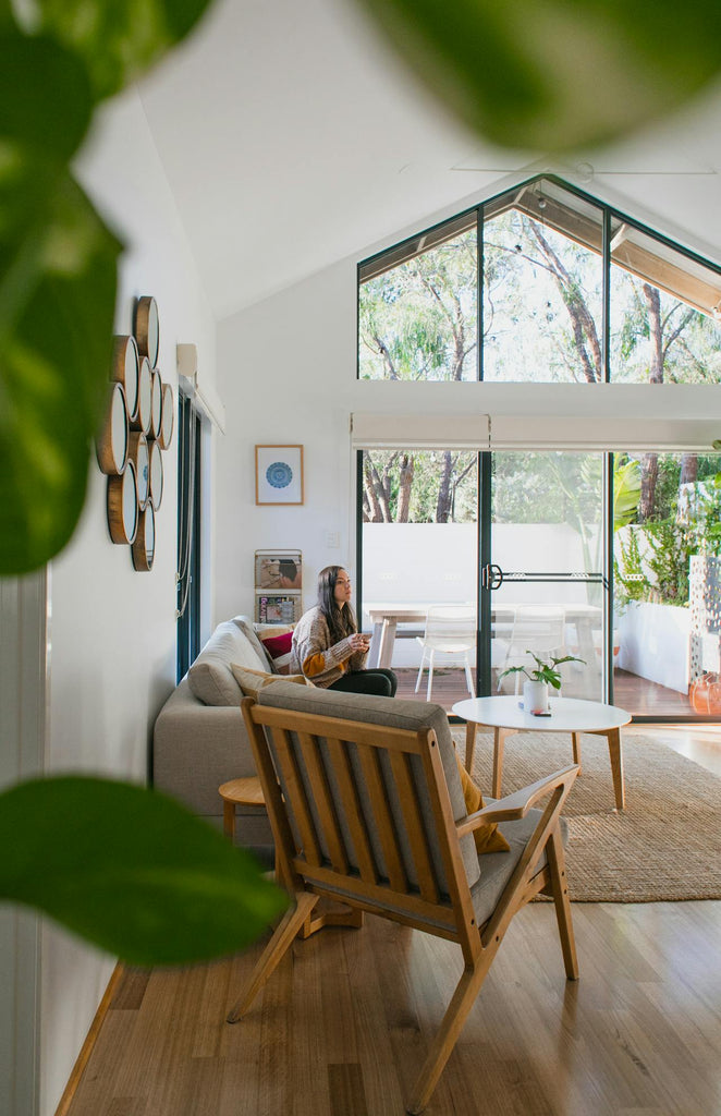 Woman sitting in modern apartment with glass wall