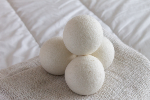 White wool dryer balls sitting on a pile of cloth