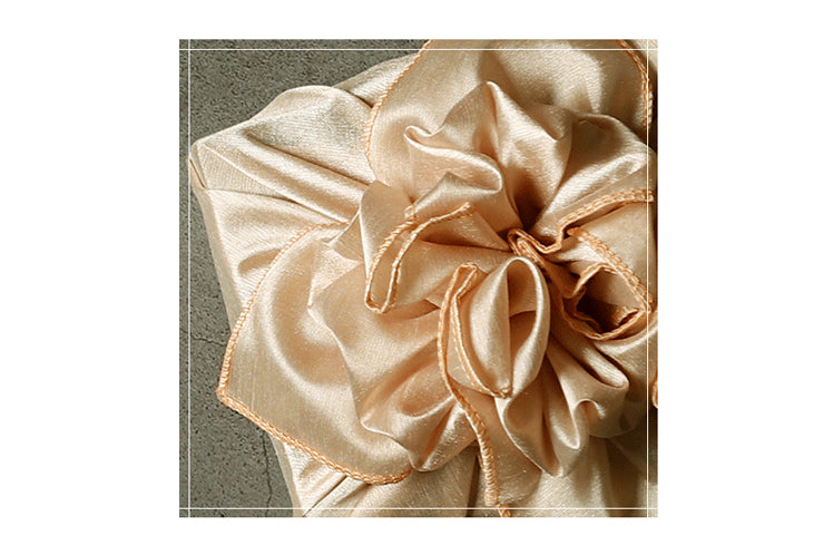 A closer look at the bow placed neatly at the top of the beige colored reusable gift wrap.