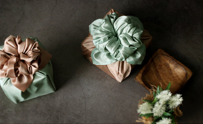 A beautiful bow at the top of this sage and khaki Bojagi wrapping is the perfect ending to wrapping presents with fabric.