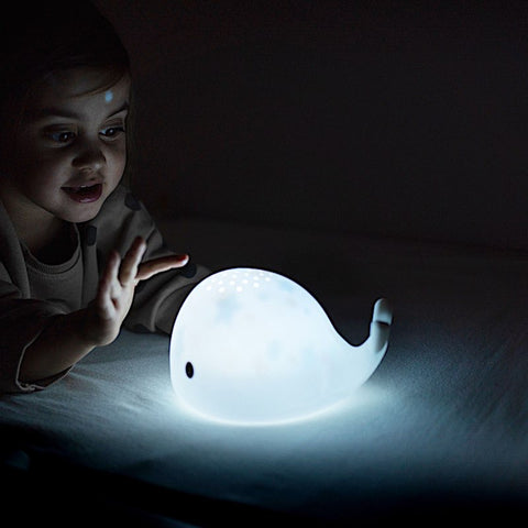 enfant qui joue dans le noir avec sa veilleuse projecteur baleine moby de flow