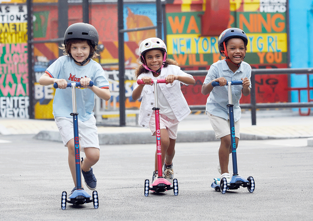 kids riding the maxi micro deluxe LED three wheel kick scooter